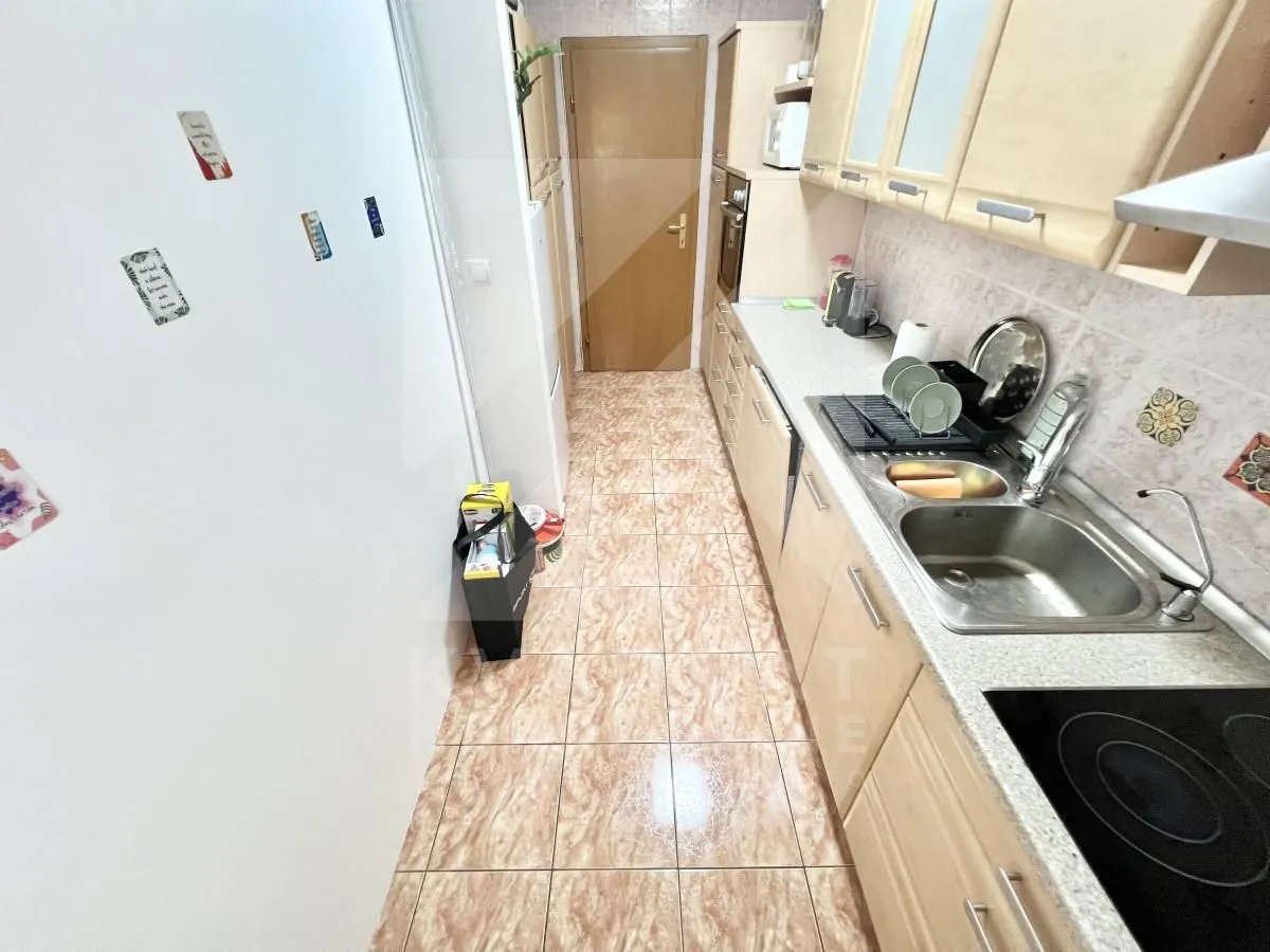 Small kitchen with wooden elements and a sink.