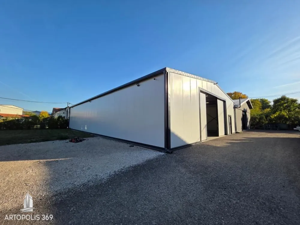 Exterior view of an industrial building with large sliding doors and a courtyard.