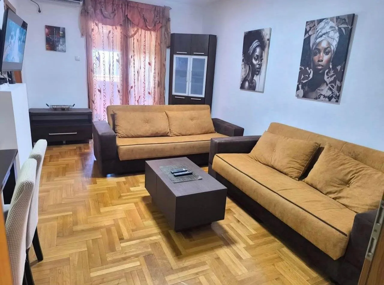 Living room with sofa set, coffee table and parquet flooring.