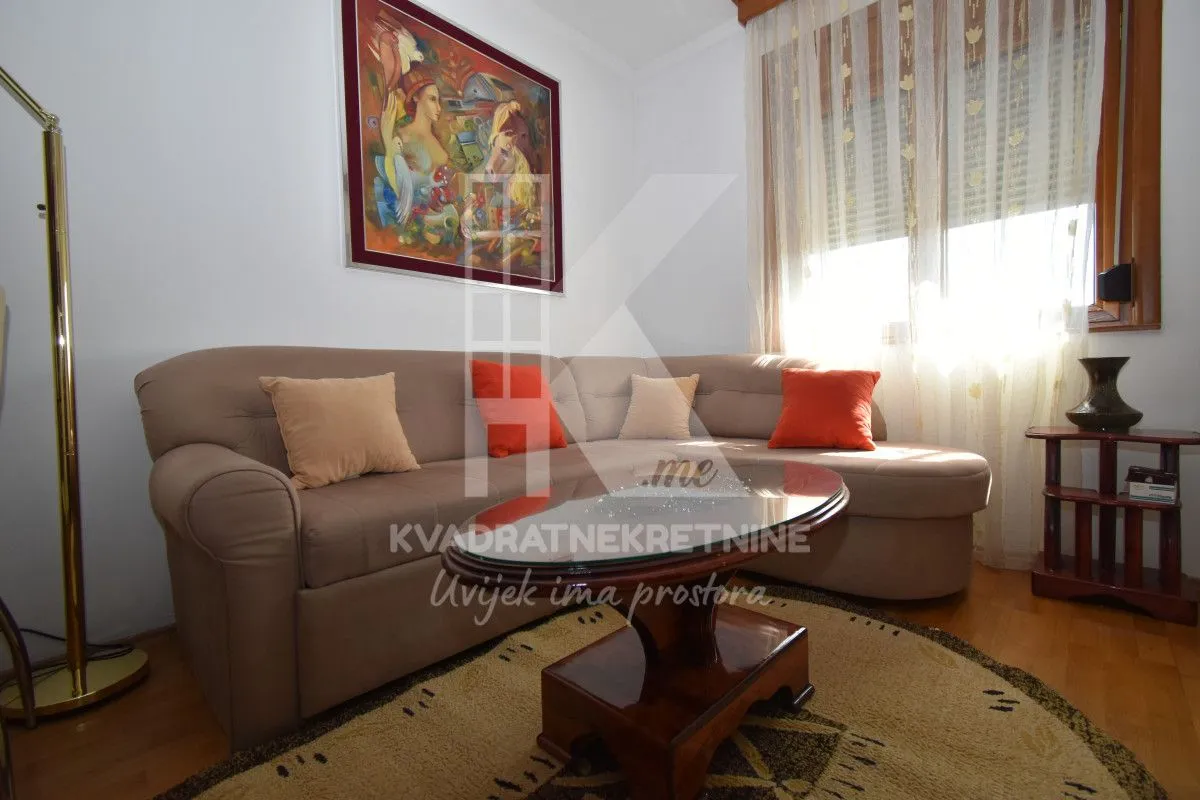 Living room with a sectional sofa, coffee table, and a painting on the wall.