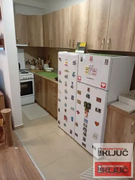 Manja kuhinja sa drvenim elementima i dva frižidera. - image 4
