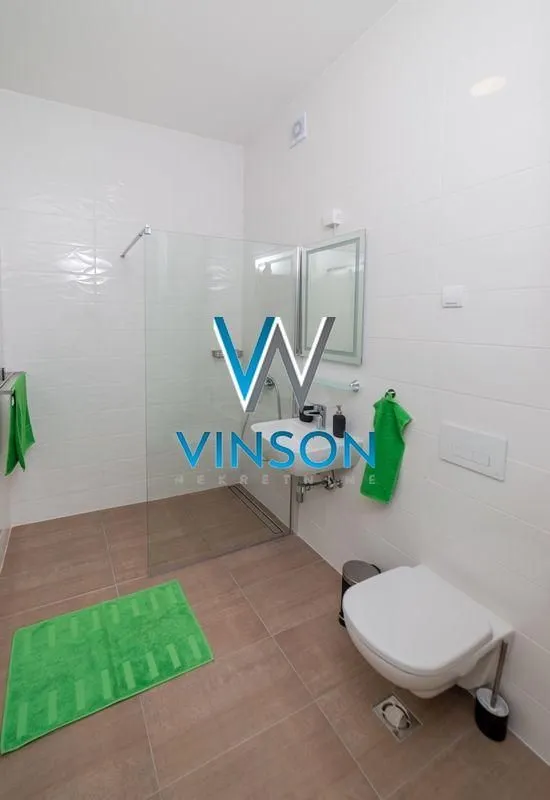 Modernly equipped bathroom with a walk-in shower and white sanitaryware.