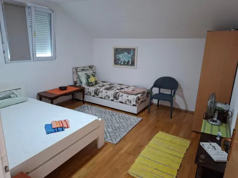 Attic bedroom with two beds and wooden flooring. - image 7