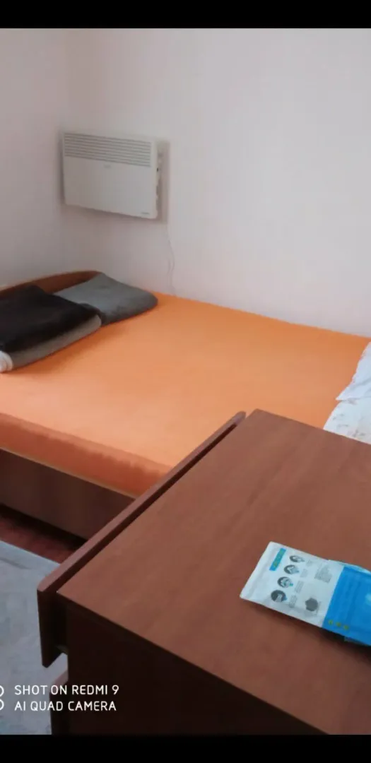 Jednostavna spavaća soba sa krevetom i stolom.