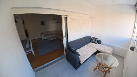 Enclosed terrace with seating furniture and a view of the living room. - image 13