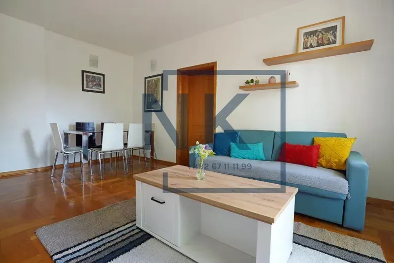 Living room with a sofa, coffee table, and dining area.