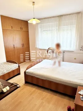 Furnished bedroom with a wooden bed and wardrobe. - image 9