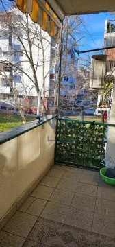 Natkriveni balkonski prostor sa pogledom na okolne zgrade i ulicu. - image 7
