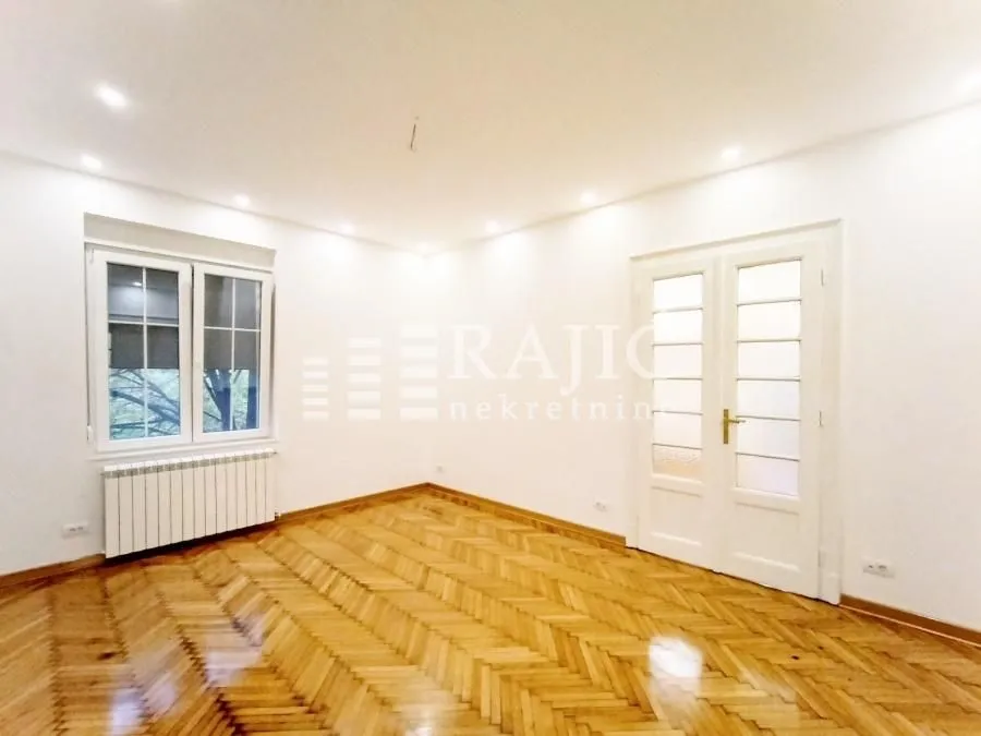 Empty room with hardwood flooring and white walls.