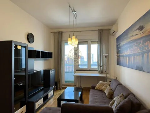 Namešten dnevni boravak sa garniturom, TV komodom i izlazom na balkon. - image 2