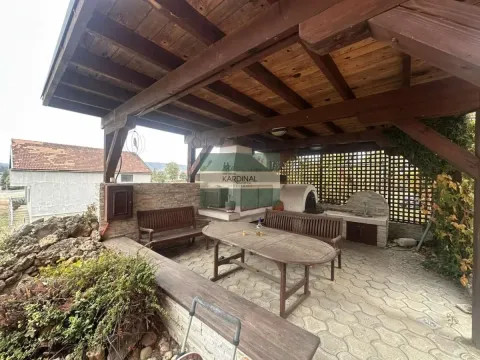 Natkrivena drvena terasa sa stolom, klupama i roštiljem u dvorištu. - image 19
