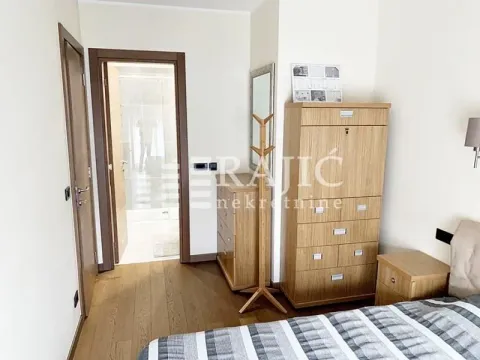 Furnished bedroom with wooden furniture and a view towards the bathroom. - image 8