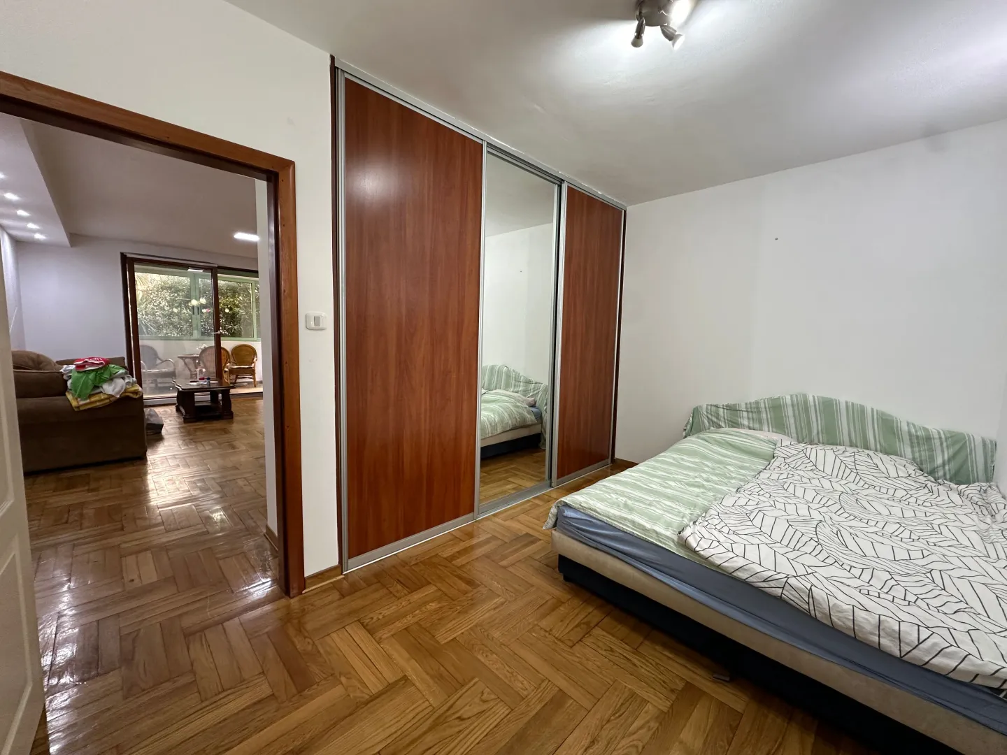 Bedroom with a bed and a large built-in wardrobe with a mirror.
