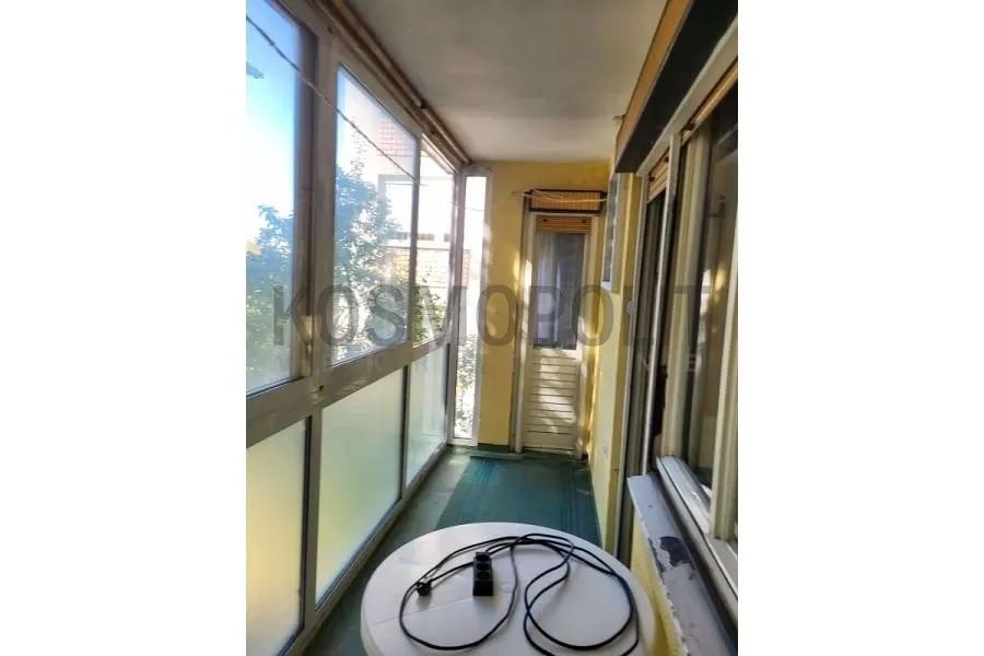 Zastakljeni balkon sa stolom i pogledom.