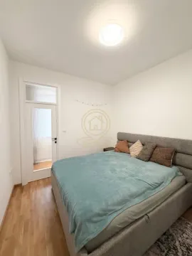 Spavaća soba sa bračnim krevetom i drvenim podom. - image 10