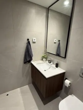 Modern bathroom tiled in grey with a washbasin and a mirror. - image 12