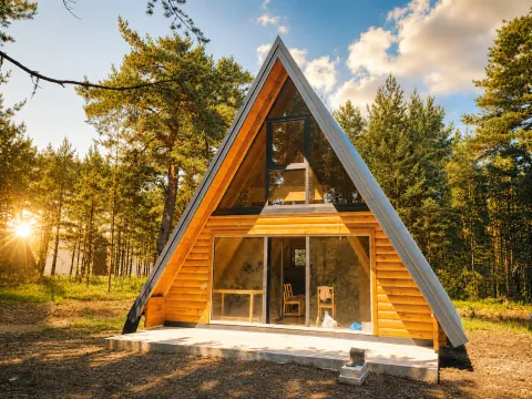 Eksterijer drvene A-frame vikendice okružene borovom šumom. - image 3