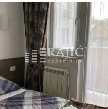 Part of a bedroom with a bed, window, and radiator. - image 5