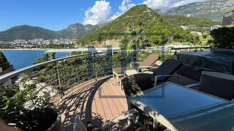 Spacious terrace with outdoor seating and sun loungers offering sea and mountain views.