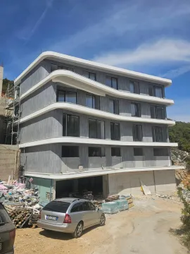 Exterior view of a multi-story residential building under construction with balconies and a gray facade. - image 12