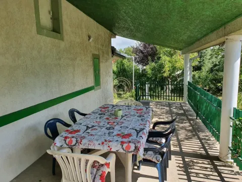 Natkrivena terasa sa stolom za ručavanje i stolicama pored kuće. - image 16