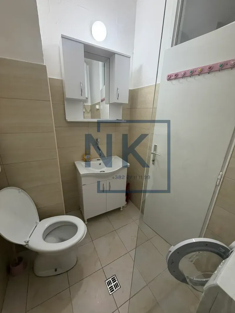 Manje kupatilo sa umivaonikom, ormarićem sa ogledalom i wc šoljom.