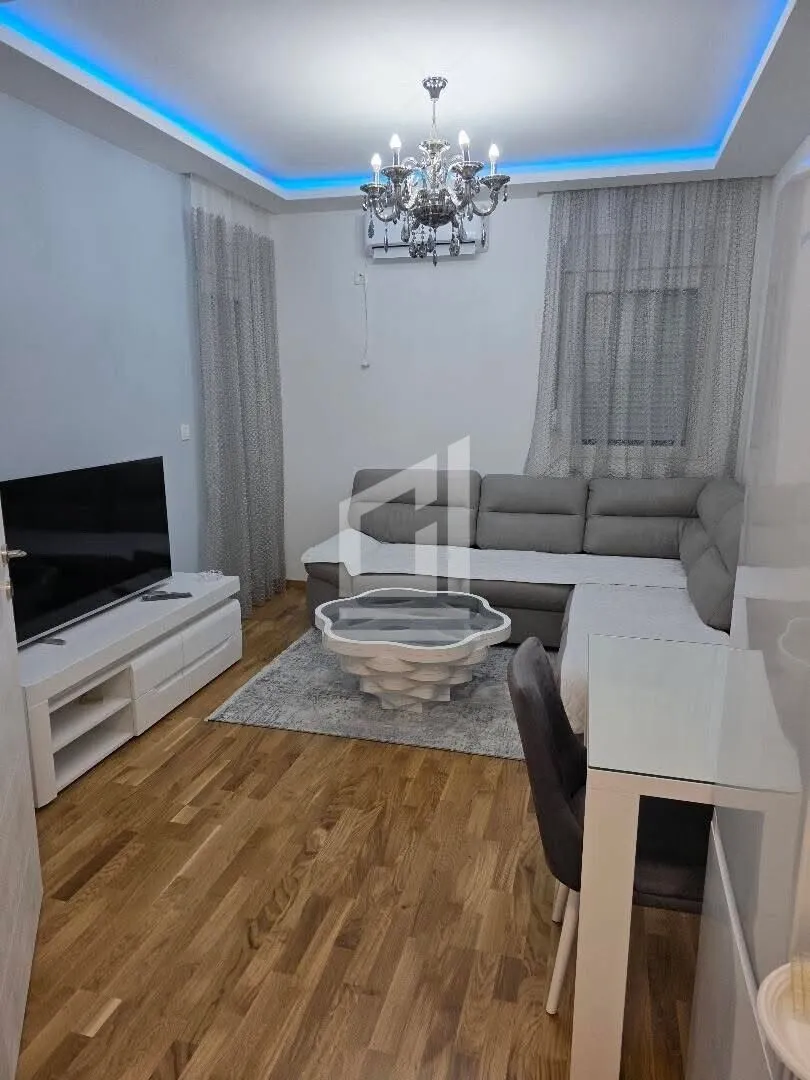 Living room with a sofa, TV, and dining table.