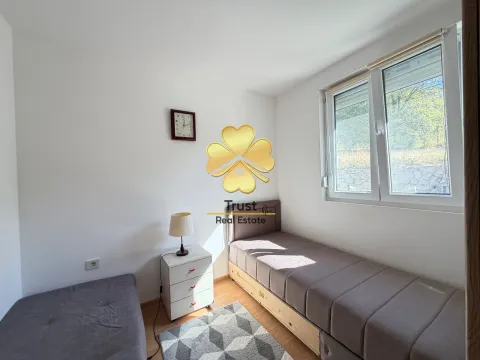 Small bedroom with two single beds, a nightstand, and a window. - image 10