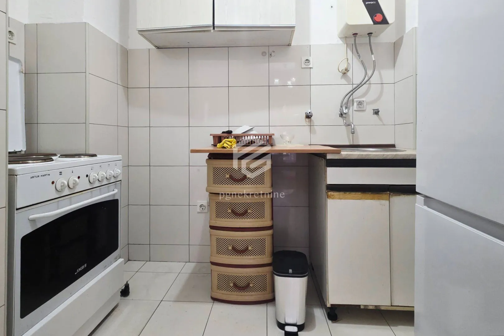 Smaller kitchen with a stove, sink, and cabinetry.