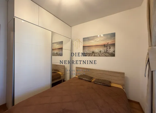 Bedroom with a double bed, large wardrobe, and a water-themed wall art.