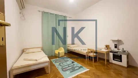 Children's bedroom with two single beds, a desk, and children's toys. - image 6