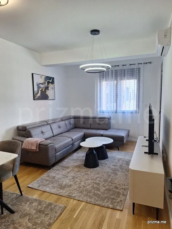 Living room with a sofa, coffee table, and TV.