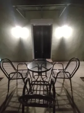 Natkrivena terasa sa stolom i četiri stolice noću. - image 12