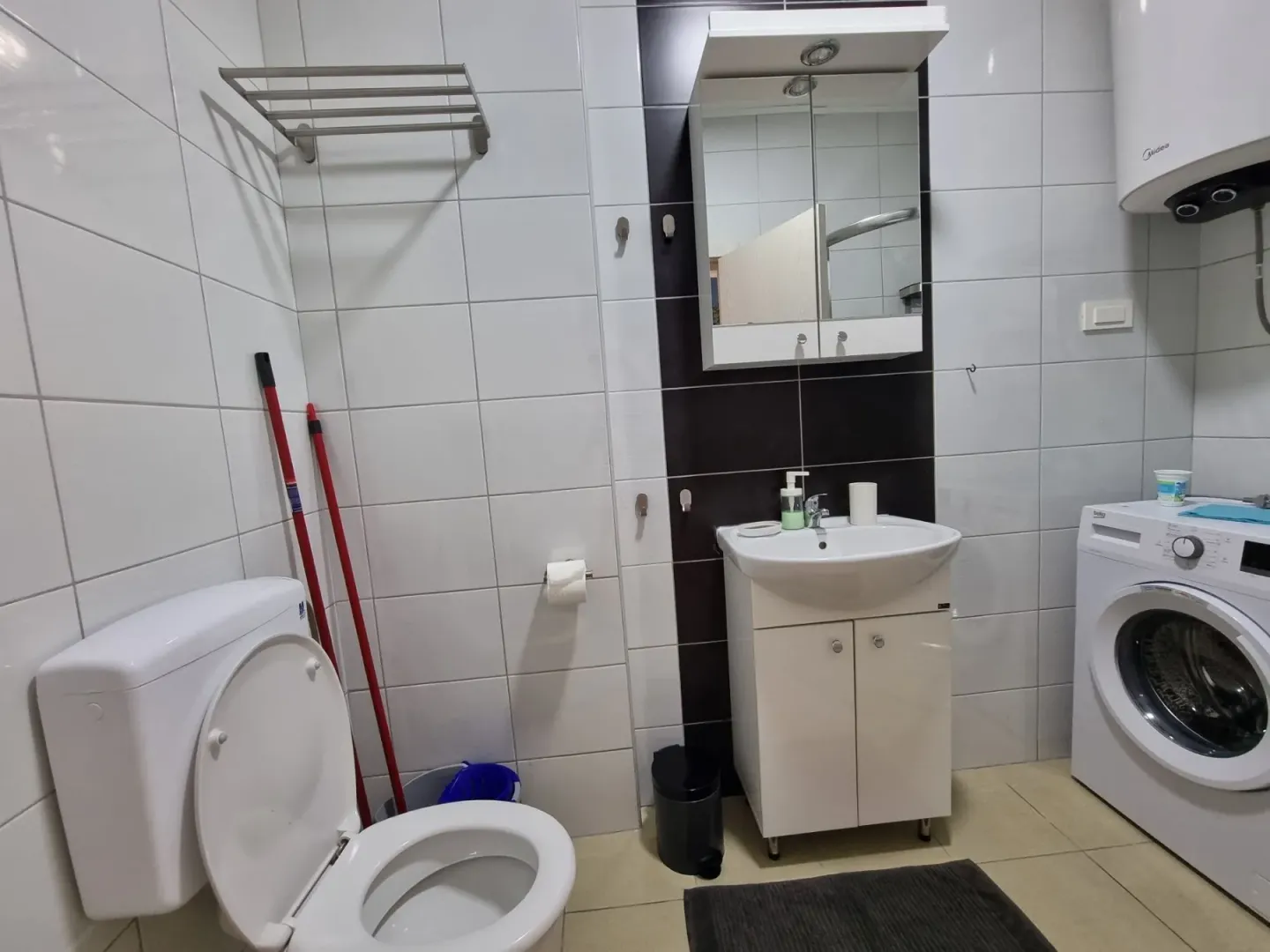 Kupatilo sa toaletom, umivaonikom i veš mašinom.