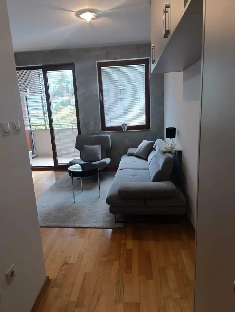 Living room with a sofa, armchair, and access to the terrace.