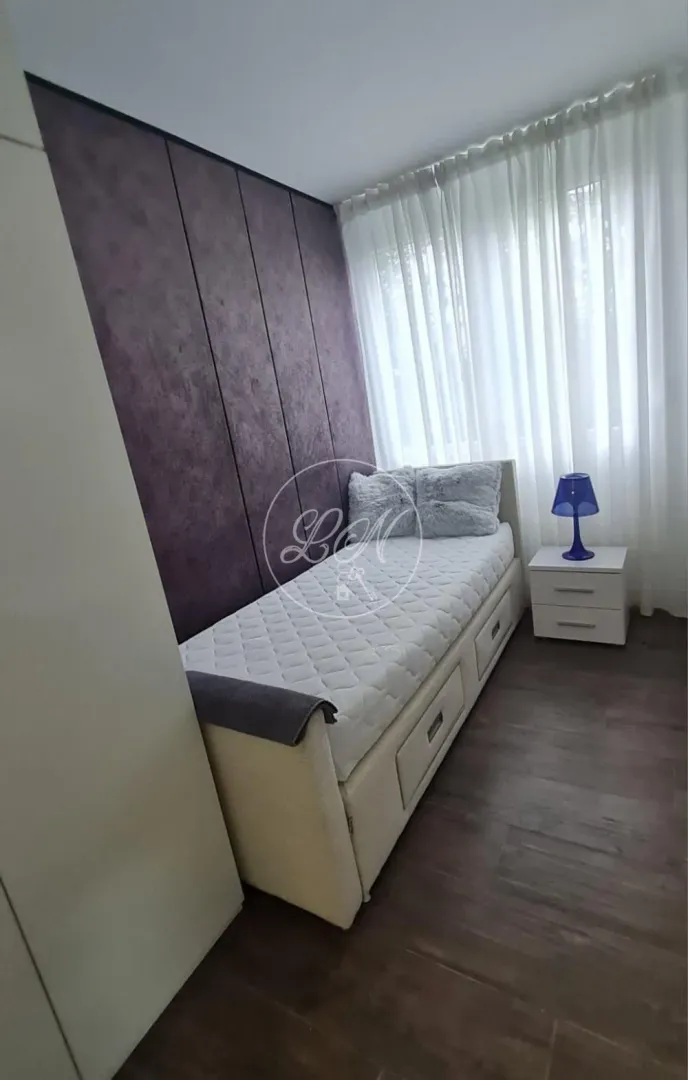 Small bedroom with a bed and a bedside table.