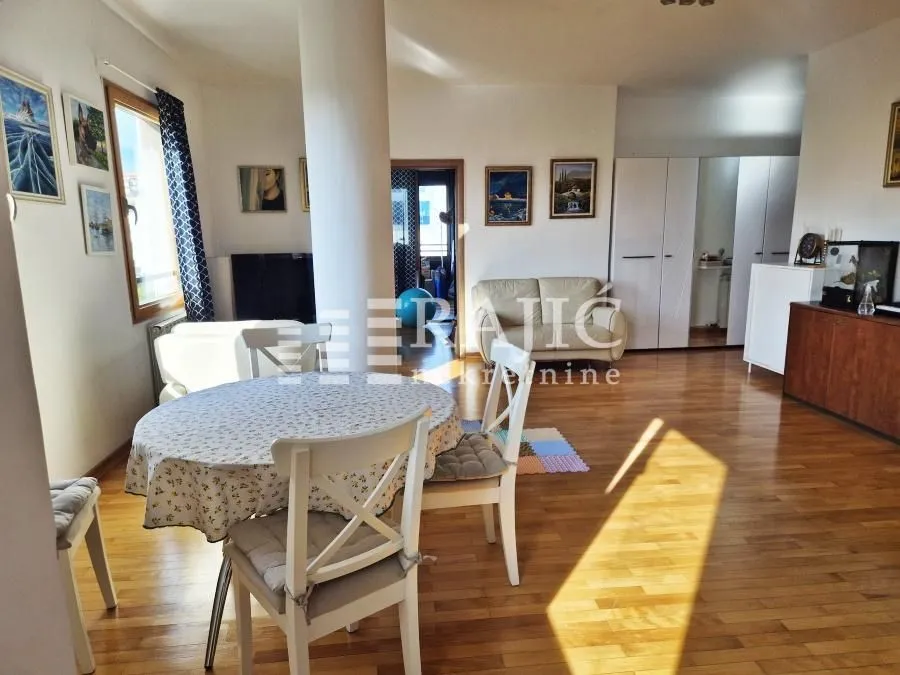Spacious living room with a dining area and wooden flooring.