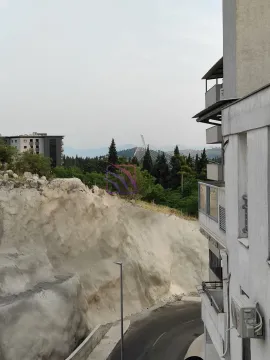Pogled sa prozora na okolne zgrade, brdo i pejzaž. - image 3