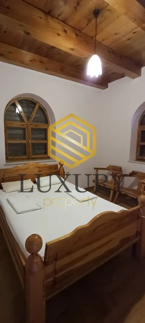 Bedroom with a wooden bed and ceiling.