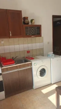 Manja kuhinja sa drvenim elementima, sudoperom, veš mašinom i frižiderom. - image 5