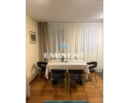 Dining area with a table and black chairs near a window with curtains. - image 4