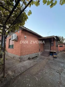 Pogled na spoljašnjost prizemne kuće sa fasadom od cigle i dvorištem. - image 3