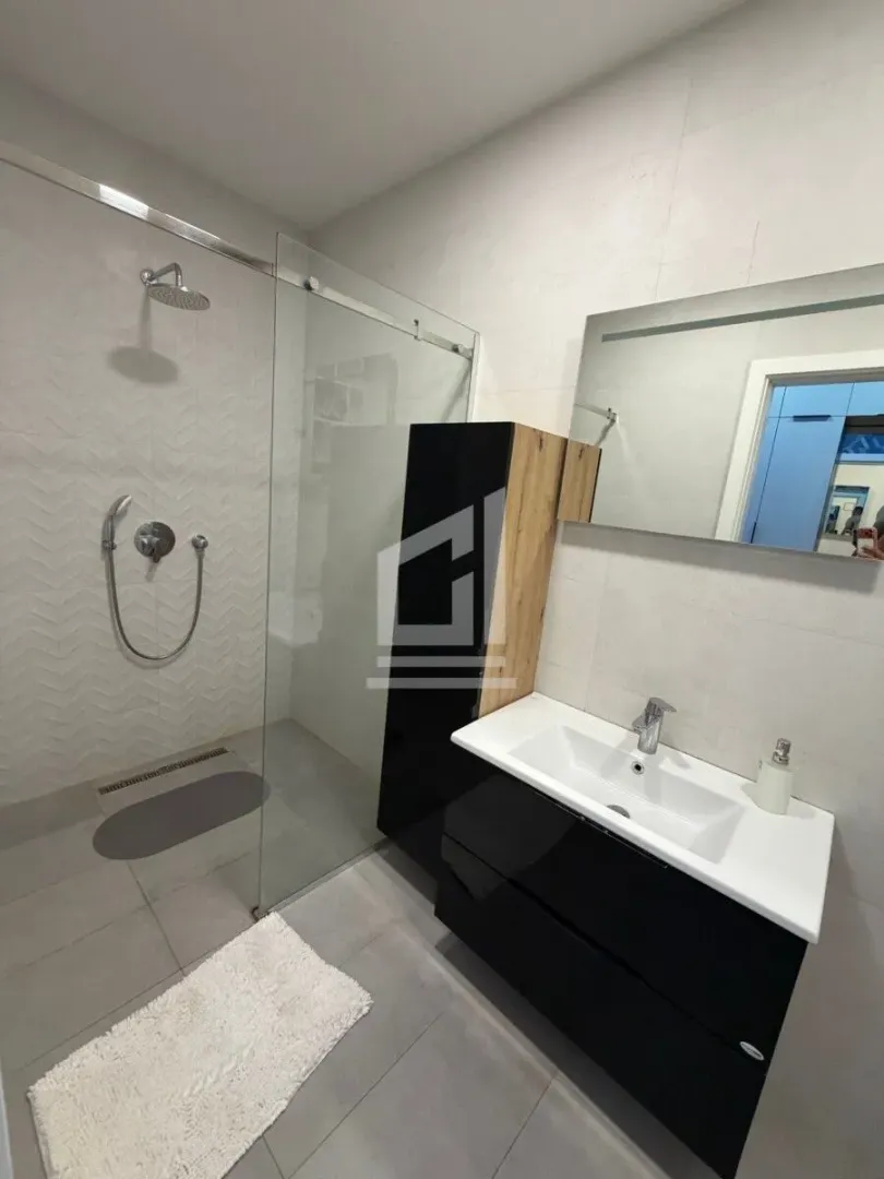Modern bathroom with a walk-in shower and vanity unit.