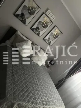 Furnished bedroom with a double bed and paintings on the wall. - image 11