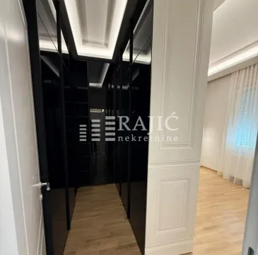 A hallway with built-in wardrobes leading into a bedroom. - image 13