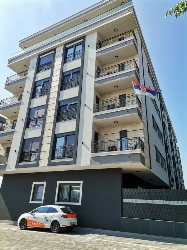 Pogled na spoljašnjost moderne stambene zgrade sa balkonima.