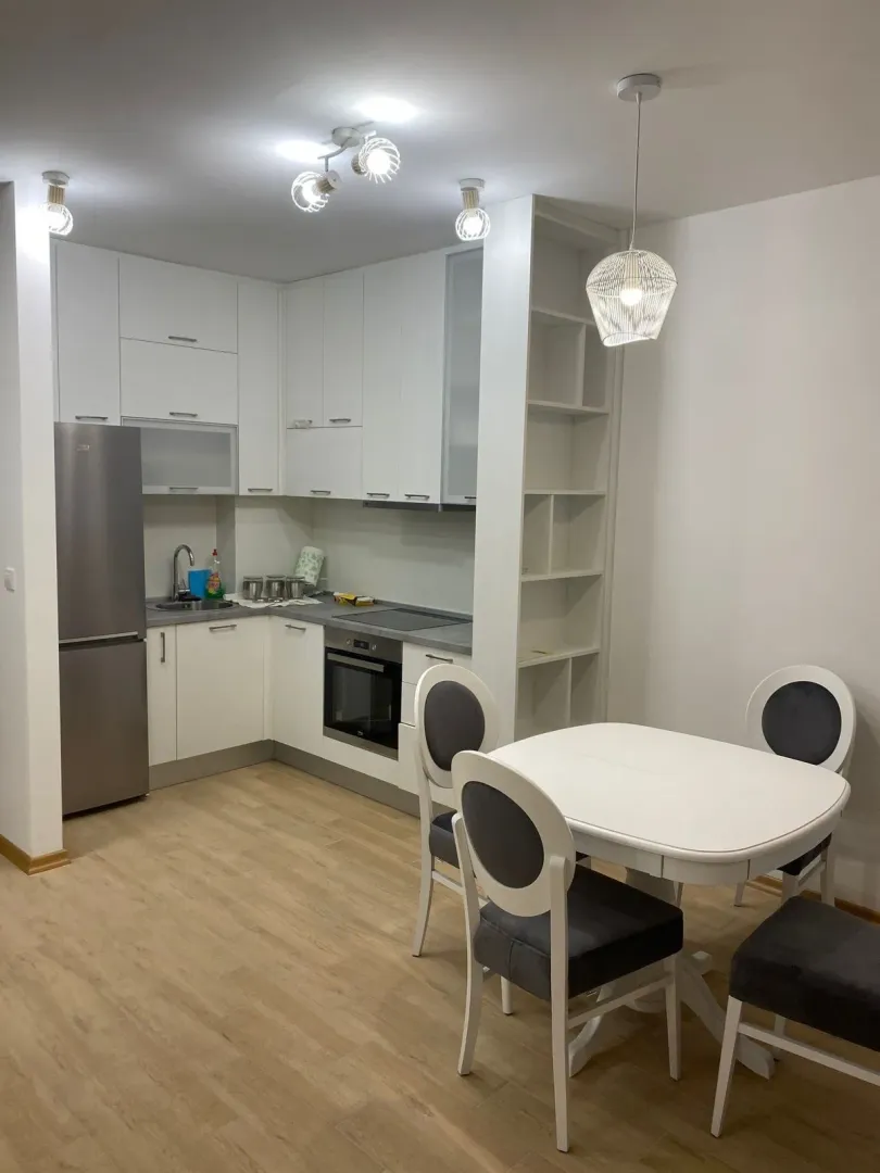 Modern kitchen with built-in units and a dining table.