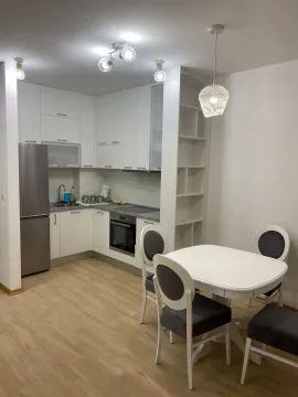Modern kitchen with built-in units and a dining table. - image 2