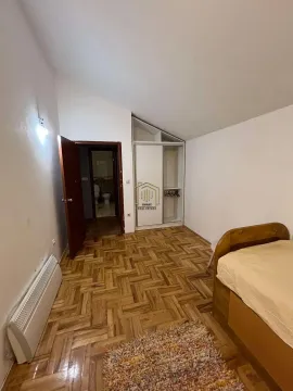 Spavaća soba sa krevetom, ugradnim ormarom i parketom na podu. - image 3