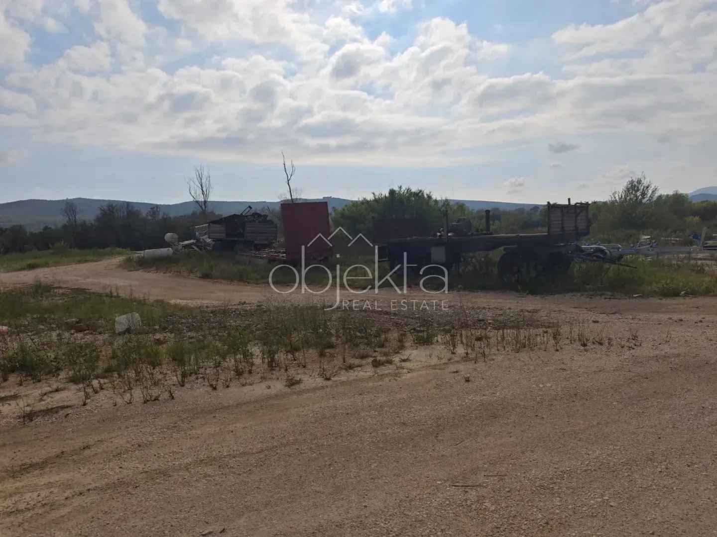 Pogled na zemljište sa prikolicama i rastinjem.
